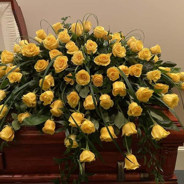 Yellow roses arranged over a casket