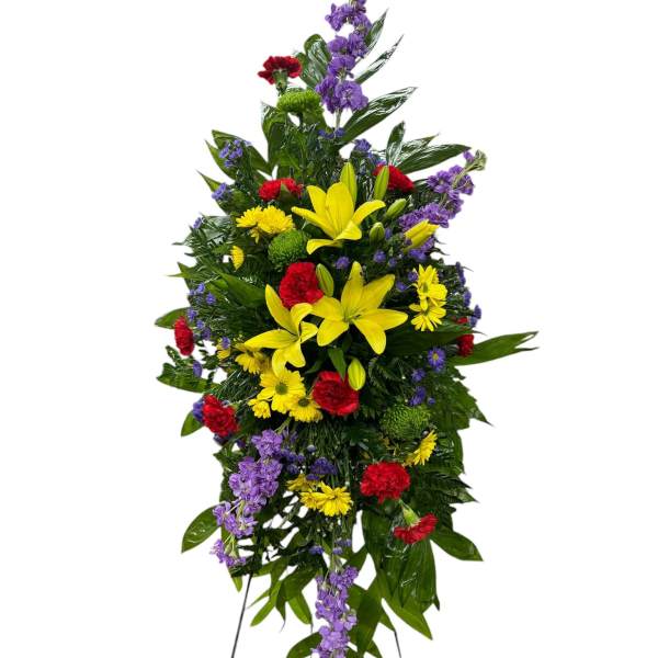 Tall standing spray with yellow lilies, red carnations, and purple flowers