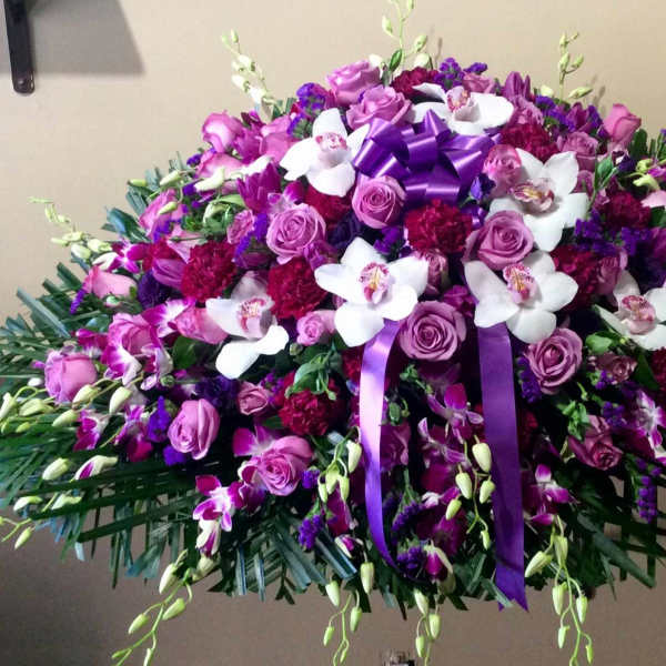 Large purple and white floral spray with ribbon accents