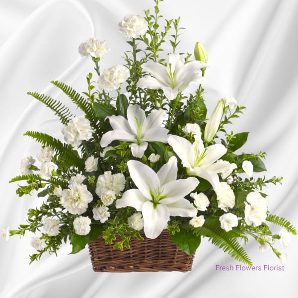 White lilies and carnations arranged in a wicker basket