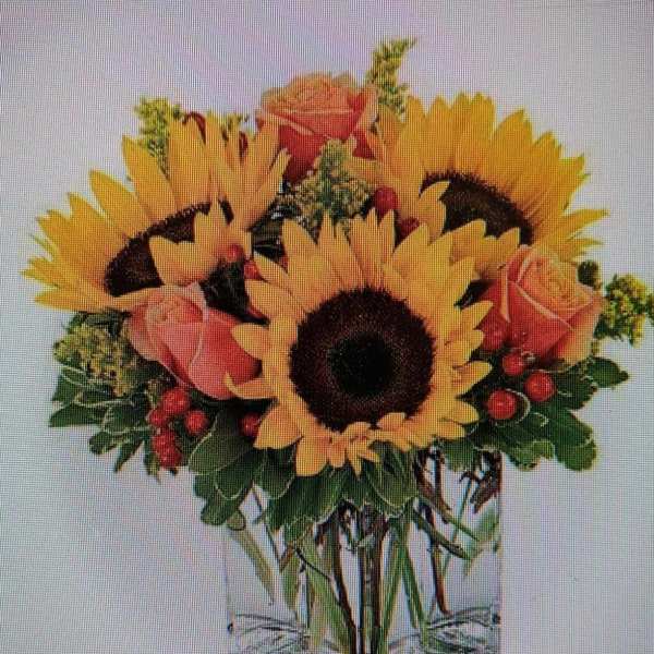 Sunflower bouquet with pink roses in a clear square vase