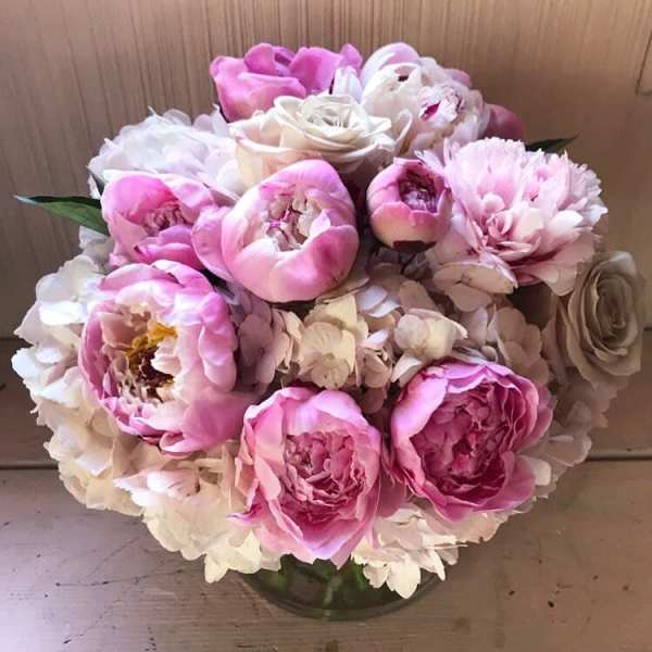 Pink and white bouquet of peonies and roses in a glass vase