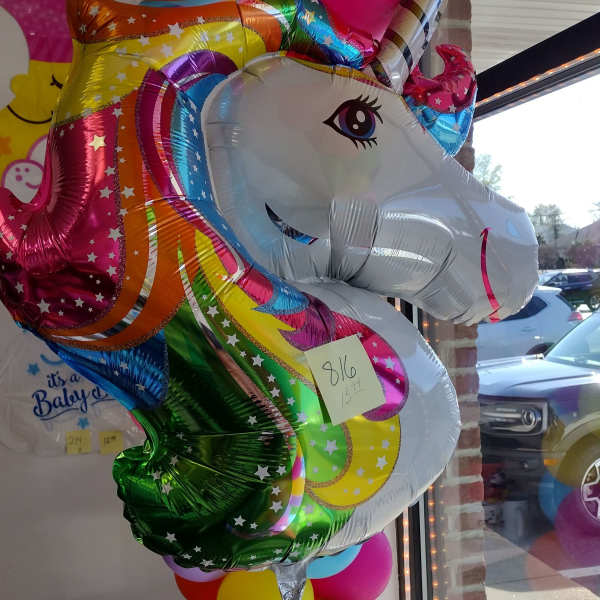 Rainbow unicorn balloon with a cluster of colorful balloons