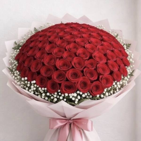 Large bouquet of red roses wrapped in pink paper with a pink ribbon