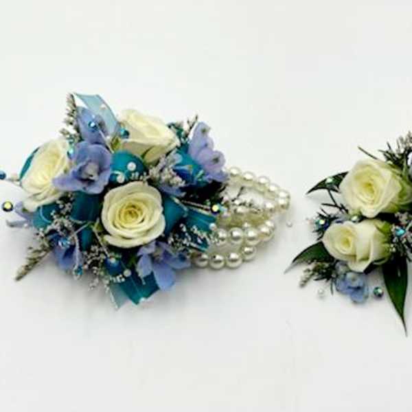 Two small floral pieces with white roses and blue accents, one with pearl strands