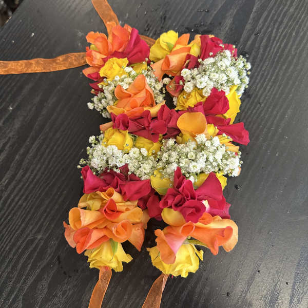 Colorful floral lei made of roses and baby's breath with orange ribbon ties
