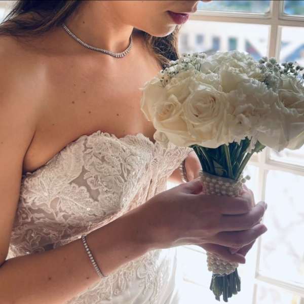Bride holding a white rose and carnation bouquet