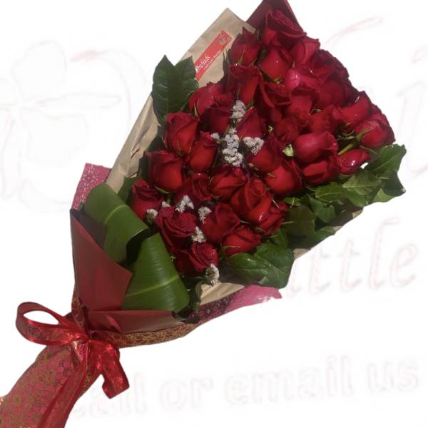 Bouquet of red roses wrapped in paper with a red ribbon