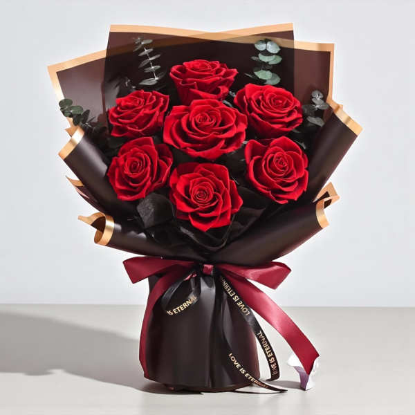 Bouquet of red roses wrapped in dark paper with a burgundy ribbon