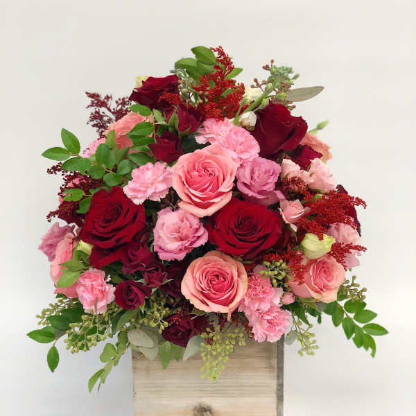 Pink and red rose arrangement in a wooden box