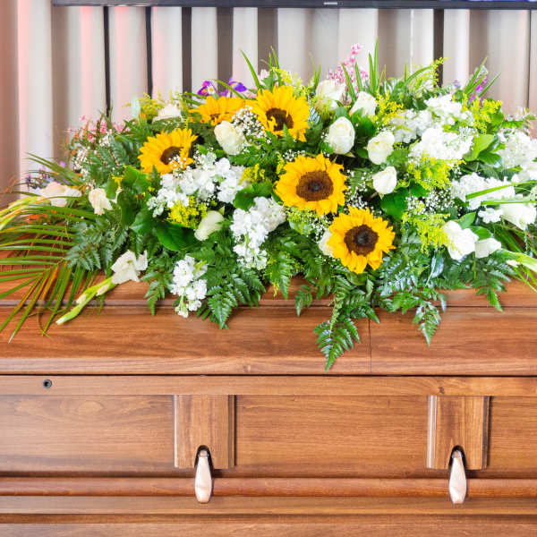 Sunflower and white floral casket spray with greenery