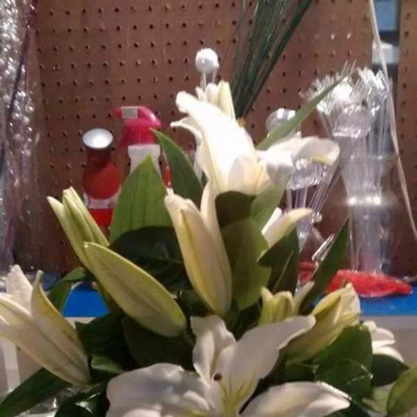 White lilies arranged in a clear glass vase