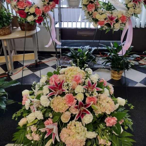 Large floral funeral wreaths and spray with pink and white flowers