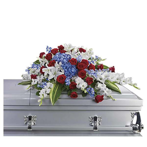 Casket spray with red roses, white lilies, and blue flowers