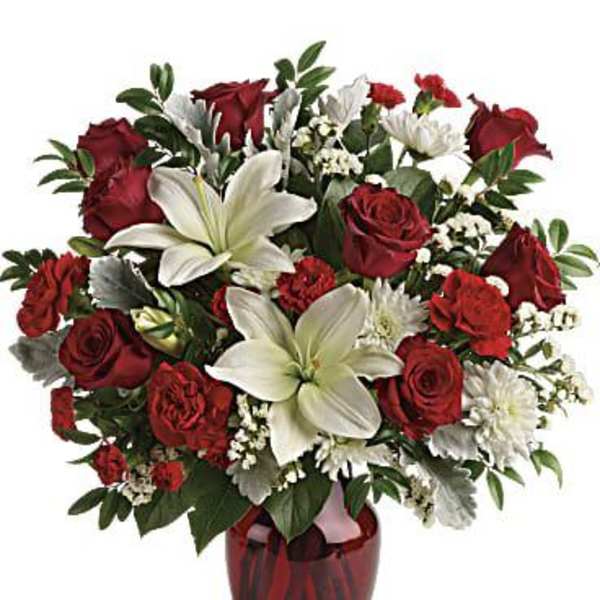 Red roses and white lilies in a red glass vase