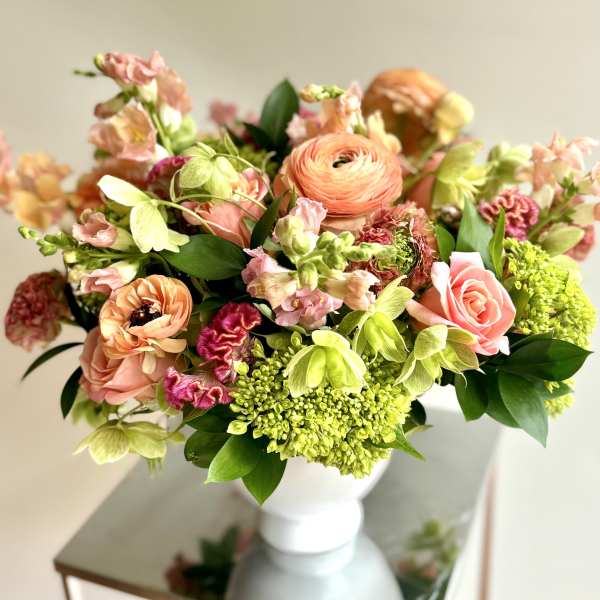 Peach and pink mixed bouquet in a white vase