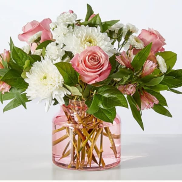 Pink roses and white chrysanthemums in a pink glass vase