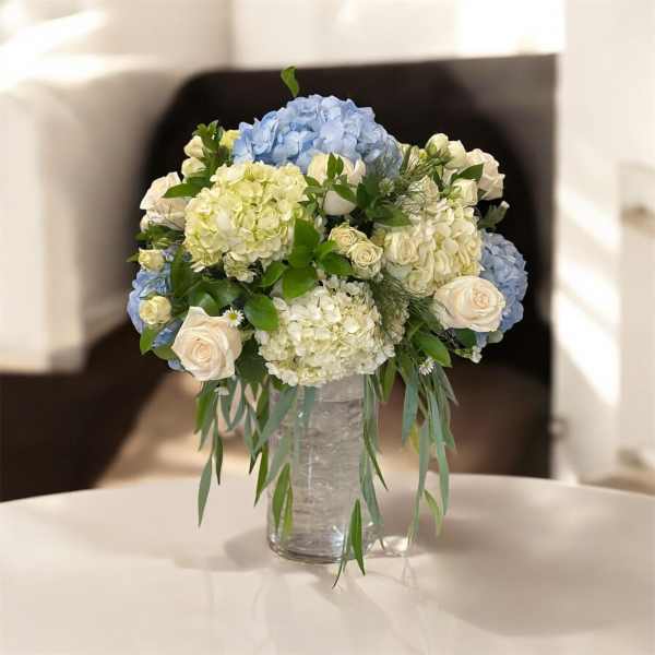 Blue and white floral arrangement in a clear glass vase