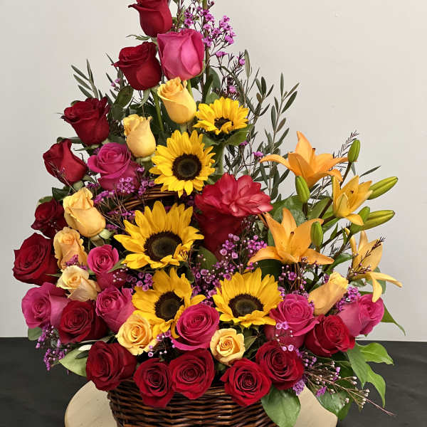 Large basket arrangement of roses, sunflowers, and lilies