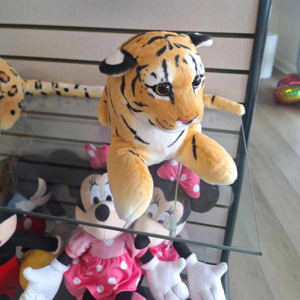 Plush tiger toy on a glass shelf
