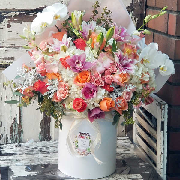 Large mixed bouquet in a white hat box with pink, orange, and white flowers