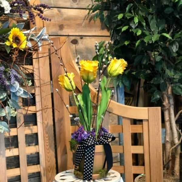 Yellow flowers in a small container tied with a black polka-dot ribbon