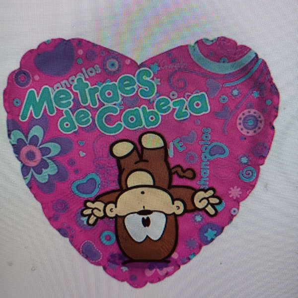Heart-shaped pink balloon with a cartoon monkey and Spanish text