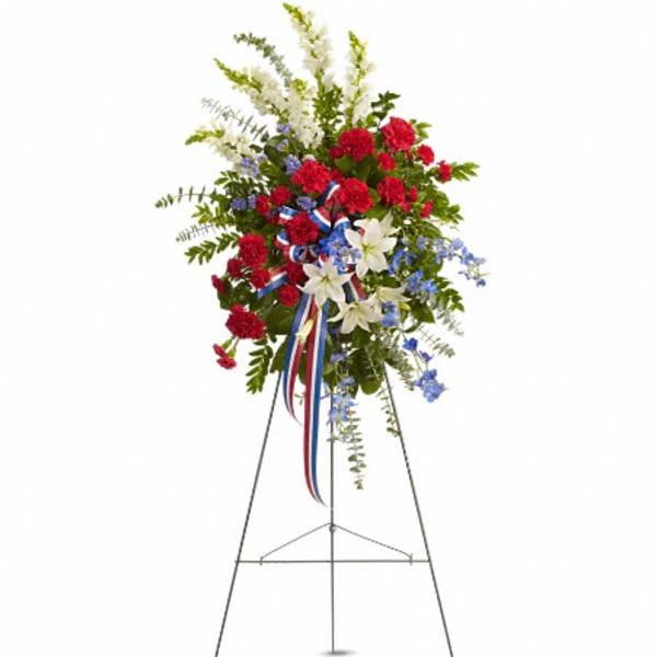 Standing floral spray with red, white, and blue flowers on an easel