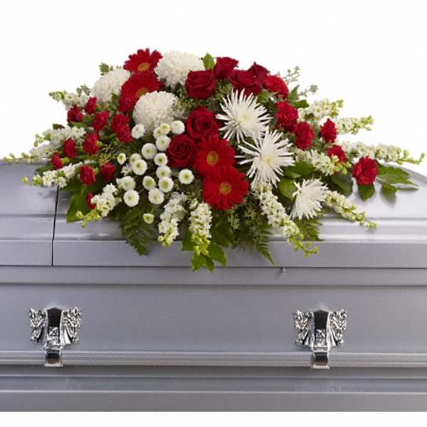 Red and white floral spray on a gray casket