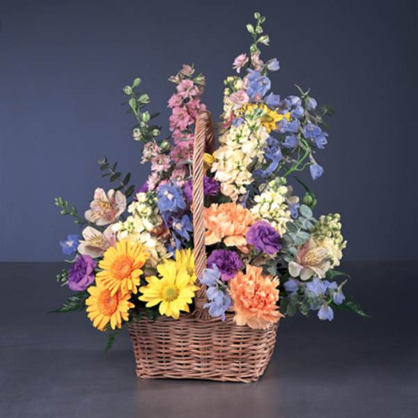 Colorful mixed flower basket arrangement in a wicker basket