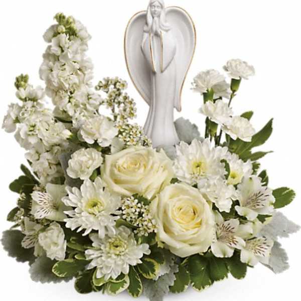 White floral arrangement with an angel figurine in the center