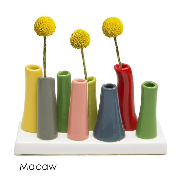 Colorful ceramic bud vases holding yellow pom-pom flowers
