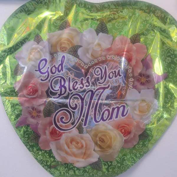 Heart-shaped floral gift with "God Bless You Mom" text