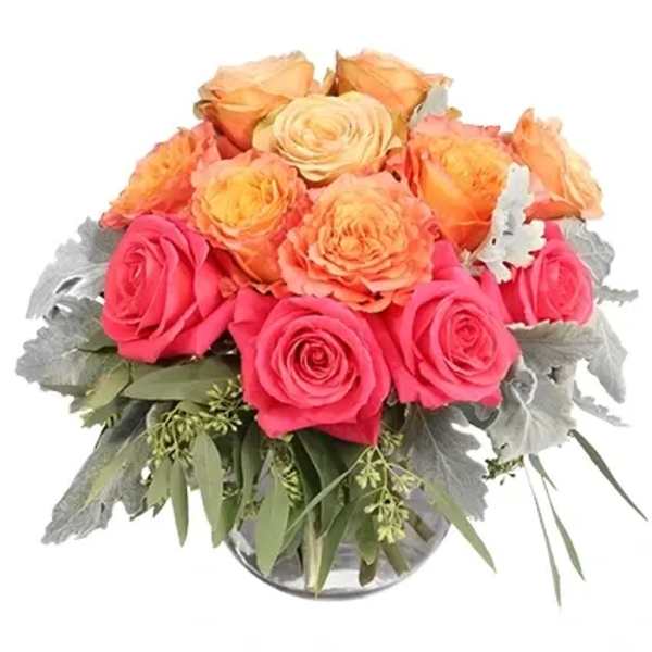 Pink and peach roses arranged in a clear glass vase