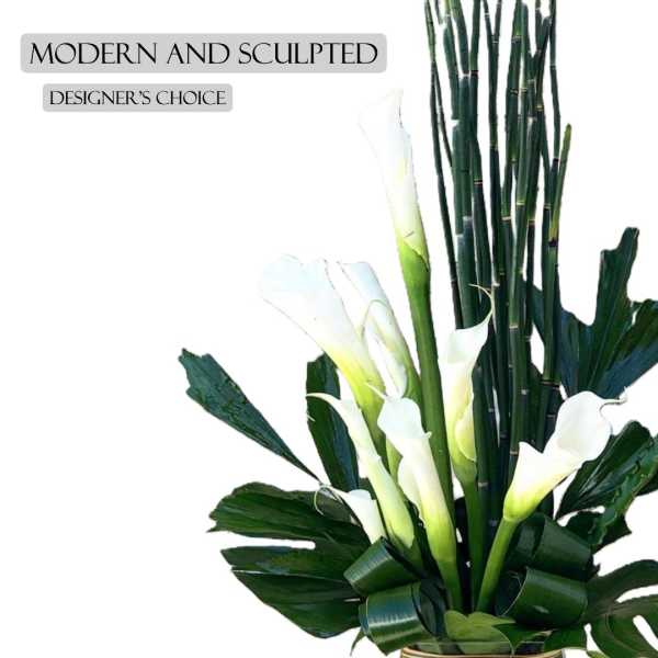 Modern arrangement of white calla lilies with tall bamboo stems