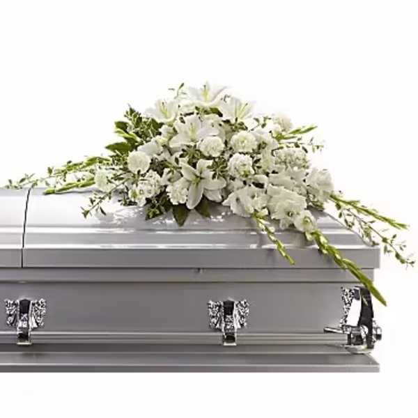 White floral casket spray on a gray casket