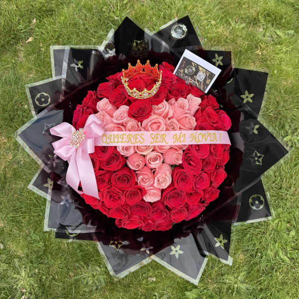 Heart-shaped bouquet of red and pink roses with a ribbon and crown