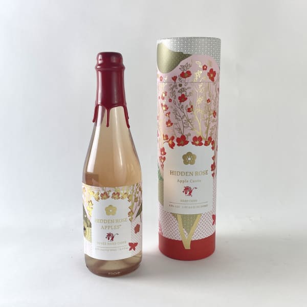 Two bottles of Hidden Rose hard cider, one in a decorative tube