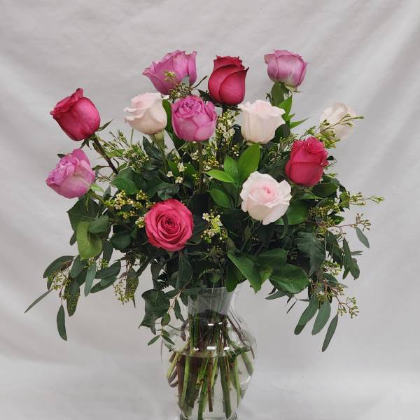 Pink and white roses arranged in a clear glass vase