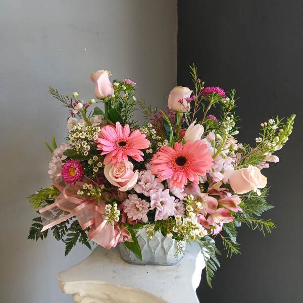 Pink mixed bouquet in a low vase with gerbera daisies and roses
