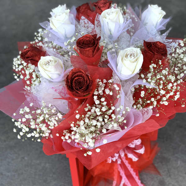 Bouquet of red and white roses wrapped in red and lavender mesh
