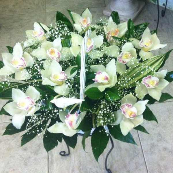 White orchid arrangement with baby’s breath on a stand