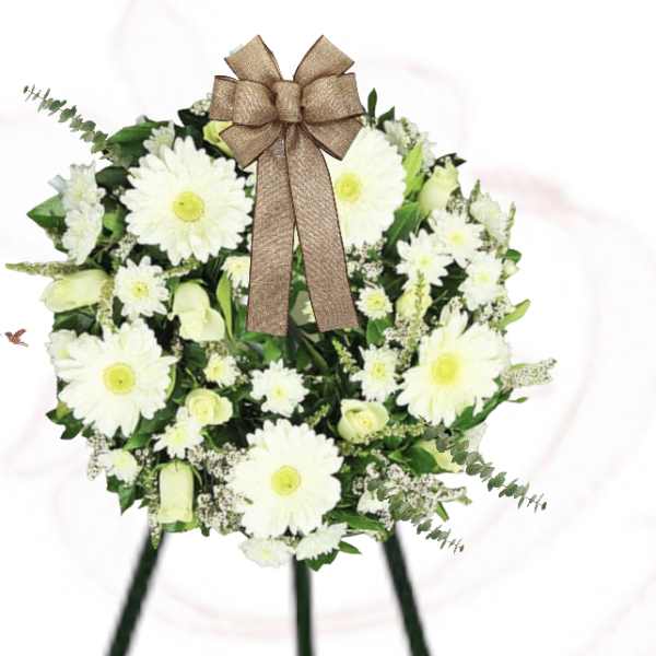 White daisy wreath with a brown bow on a stand