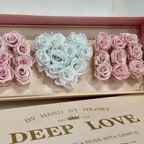 Box of pastel roses arranged in three heart shapes