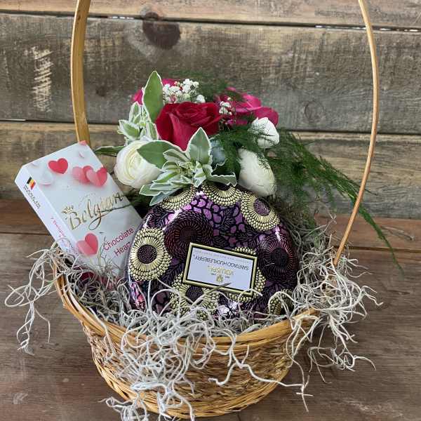 Basket of red and white roses with chocolates and a heart-shaped gift