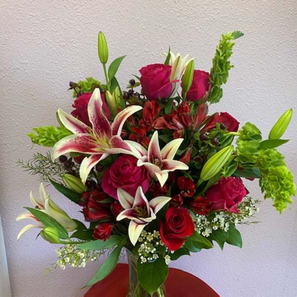 Bouquet of red roses and white lilies in a clear glass vase