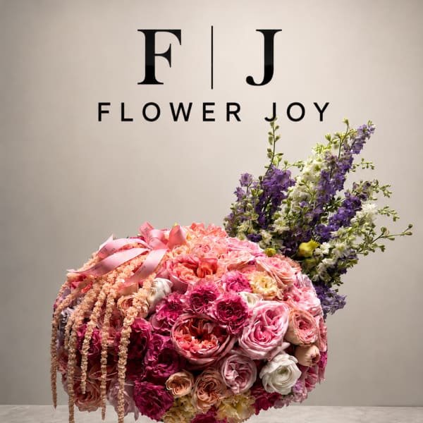 Large pink and purple floral arrangement in a pedestal vase