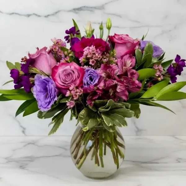 Pink and purple mixed bouquet in a clear glass vase