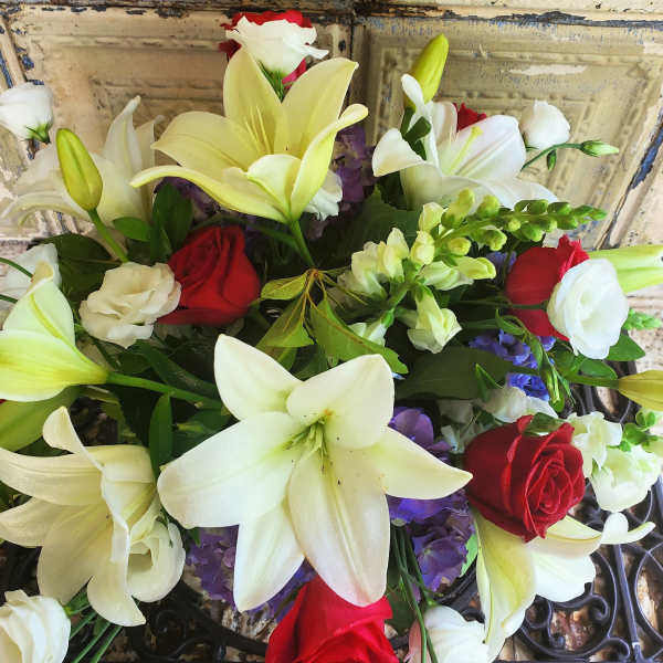 Bouquet of white lilies and red roses with purple accents