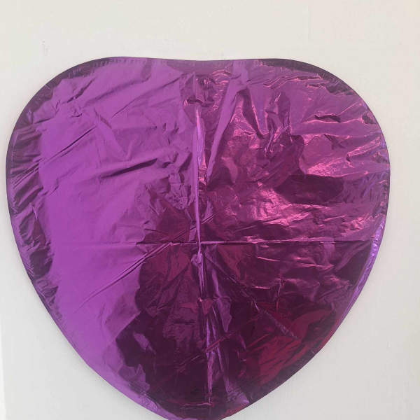 Purple heart-shaped foil balloon on a white background
